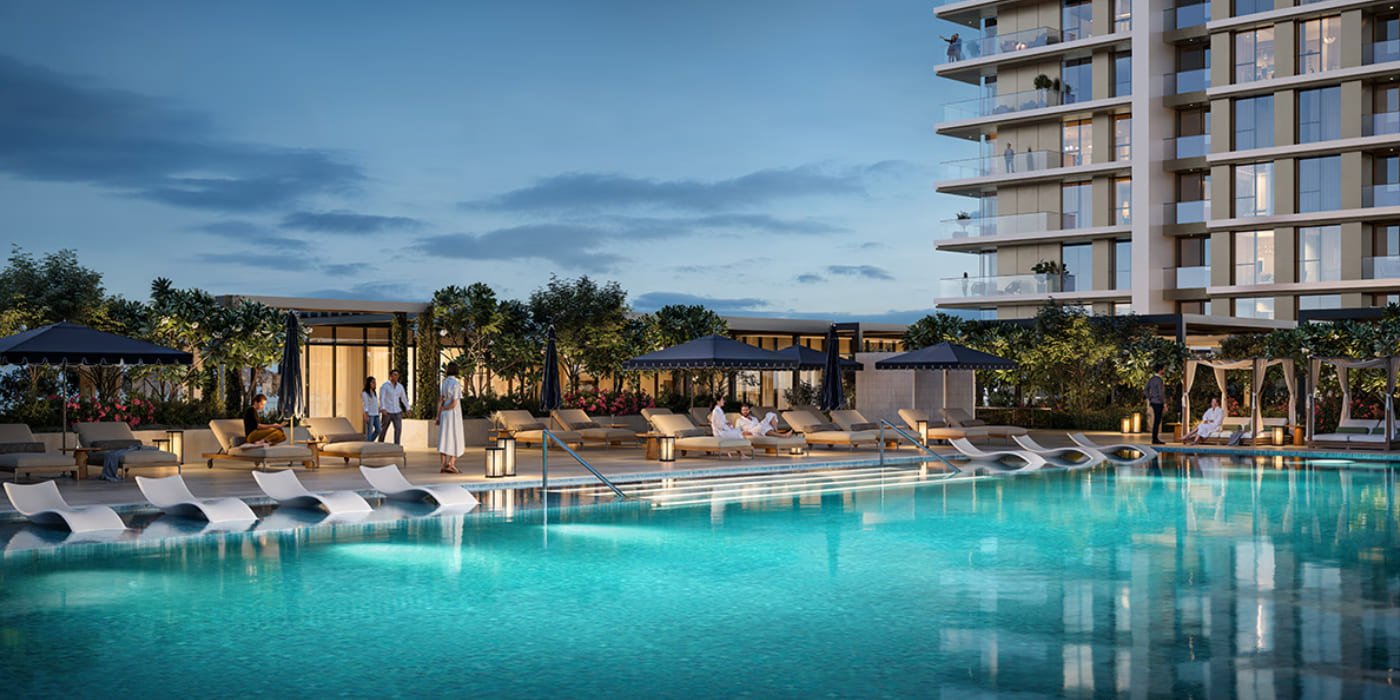 The podium pool deck at Valia at dusk, with loungers, cabanas and the tower above